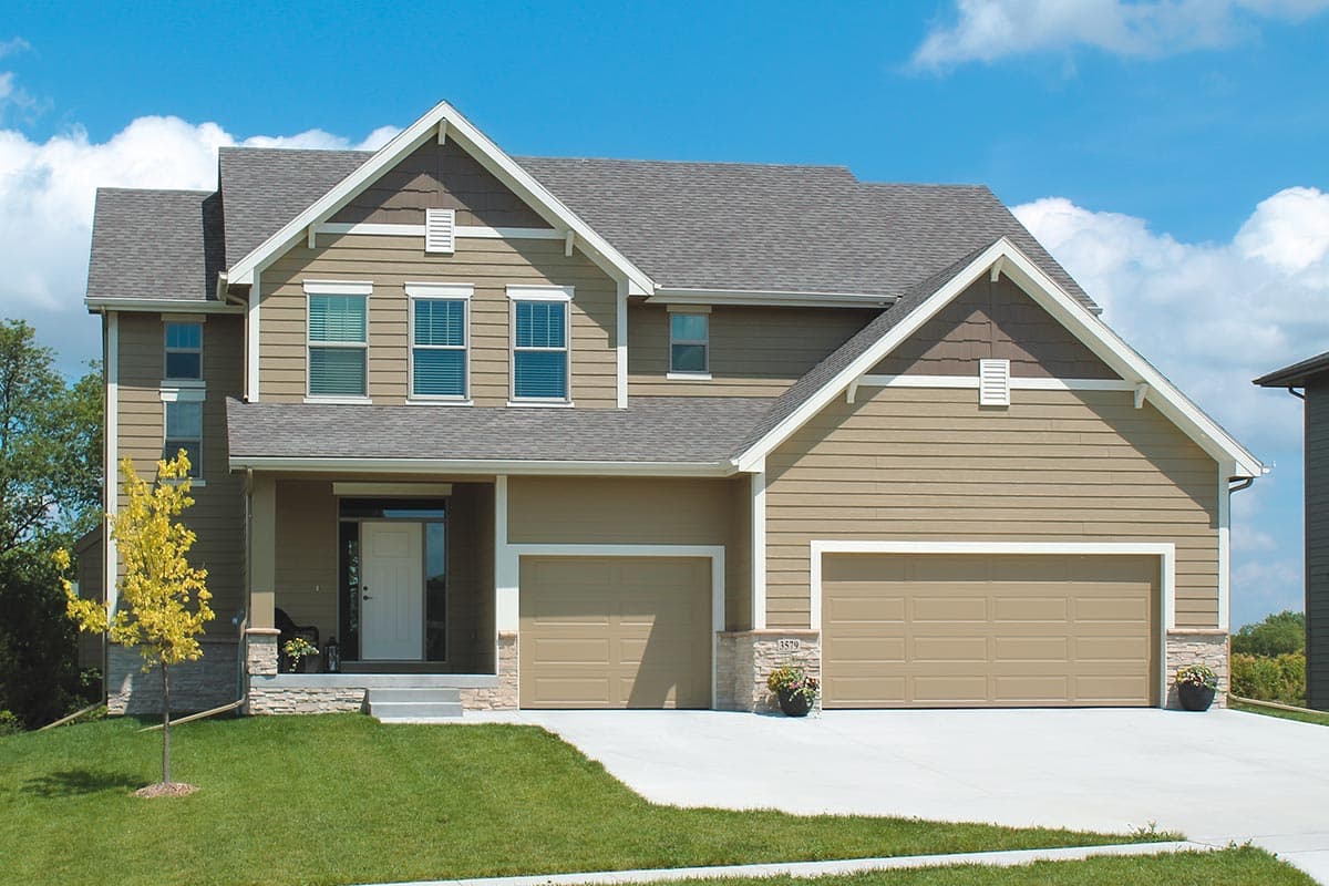 House plan exterior. Two-story house in Craftsman style. Features include front-facing gables, a covered porch, and a two-car garage.