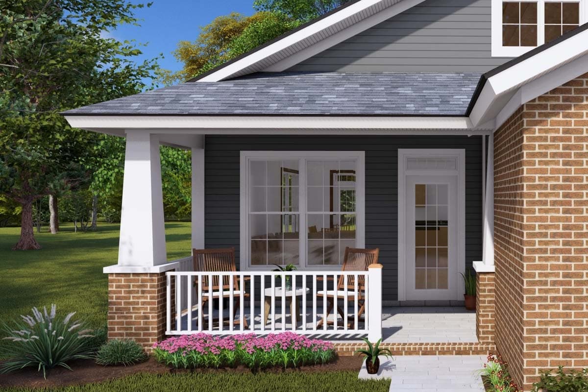House plan exterior: One-story home with covered front porch, brick base, white railing, and double-hung windows.