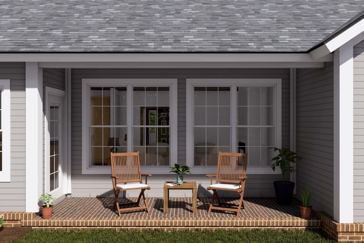 House plan exterior rendering showing a covered porch with brick flooring, two chairs, a table, and large windows.