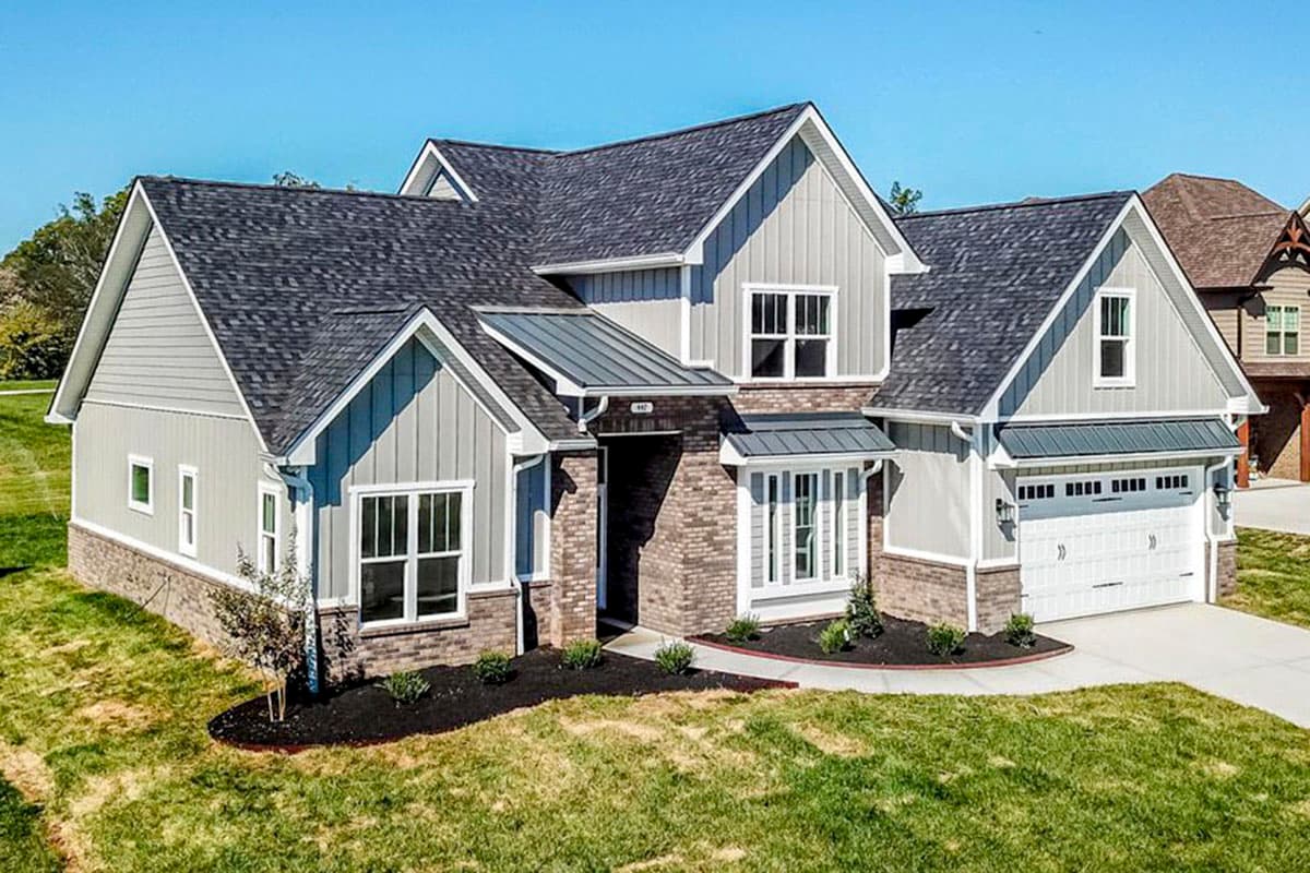 House plan exterior featuring a two-story Modern Farmhouse style with vertical siding, brick base, multiple gables, and a three-car garage.