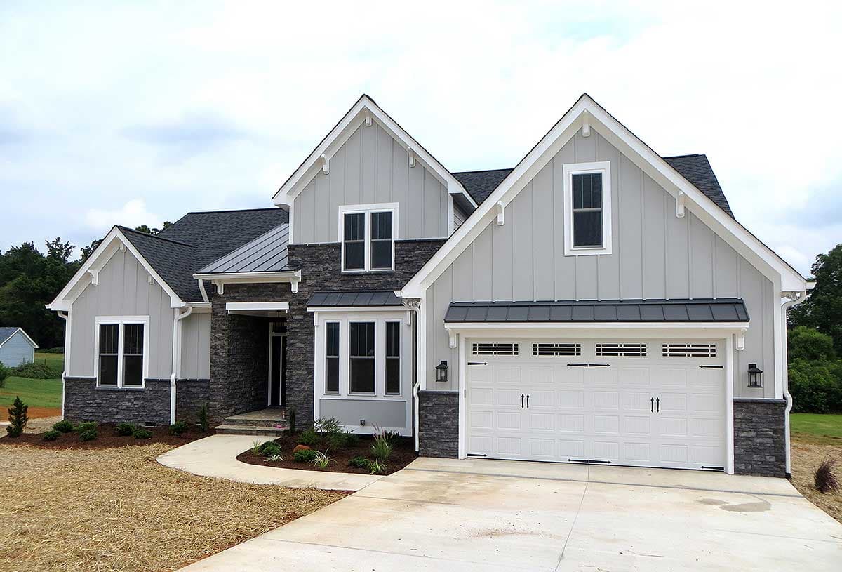 Modern Farmhouse house plan exterior with board and batten siding, stone accents, multiple gables, and a two-car garage.