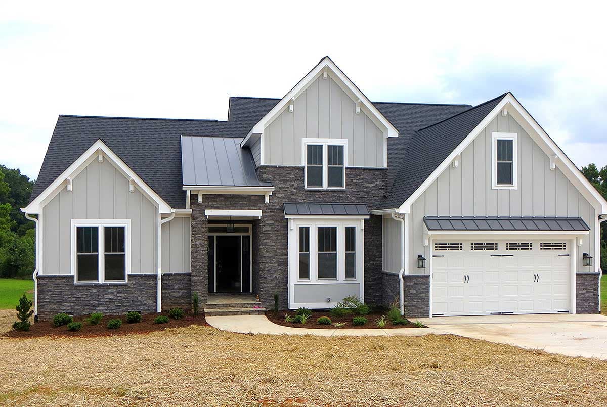 House plan exterior of a two-story Modern Farmhouse with stone accents, gables, dormers, and an attached two-car garage.