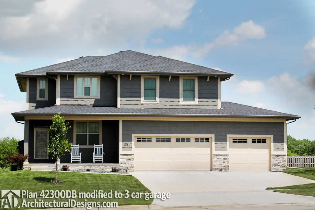 House plan exterior: Two-story home with a covered front porch, gabled rooflines, and a three-car garage.