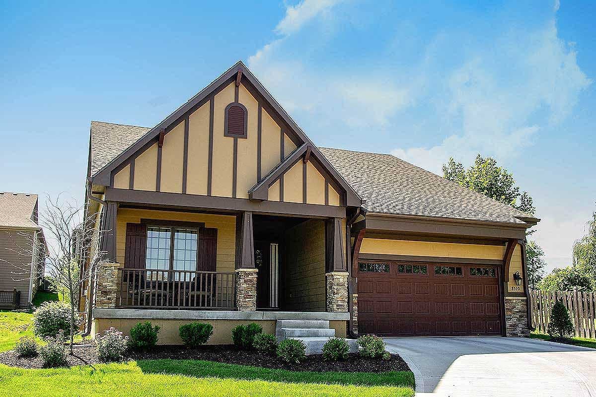 Craftsman style house plan exterior with covered front porch, stone accents, and a two-car garage.