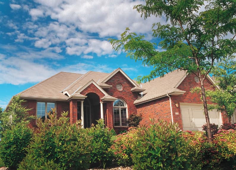 House plan exterior: Brick home with arched entryway, gables, dormers, and attached garage. Two stories visible.