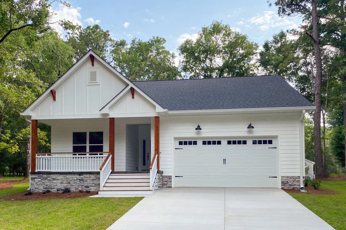 House plan exterior with Craftsman-style elements, one story, front porch, gables, and attached garage. Stone veneer accents the foundation.