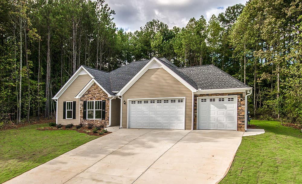 House plan exterior: Traditional style, one story, with dual garage doors, stone accents, and prominent gables.