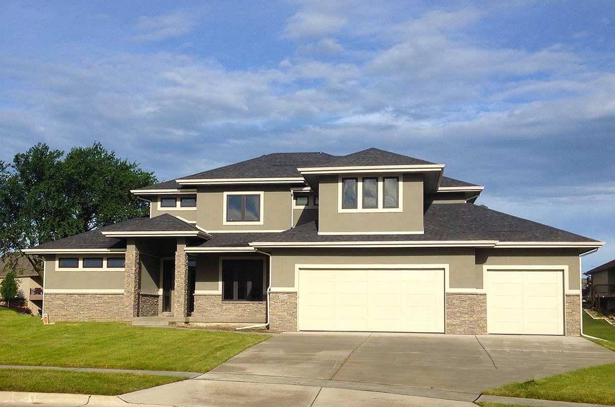 House plan exterior shows a two-story Modern house with a three-car garage, stacked stone accents, and varied rooflines.