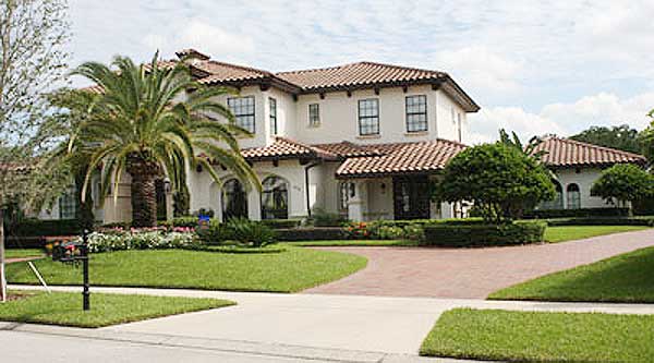 Two-story Mediterranean house plan exterior with tile roof, arched windows, and covered entryway.