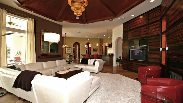 Great room with sectional sofa, fireplace wall, kitchen bar, and domed wood ceiling.