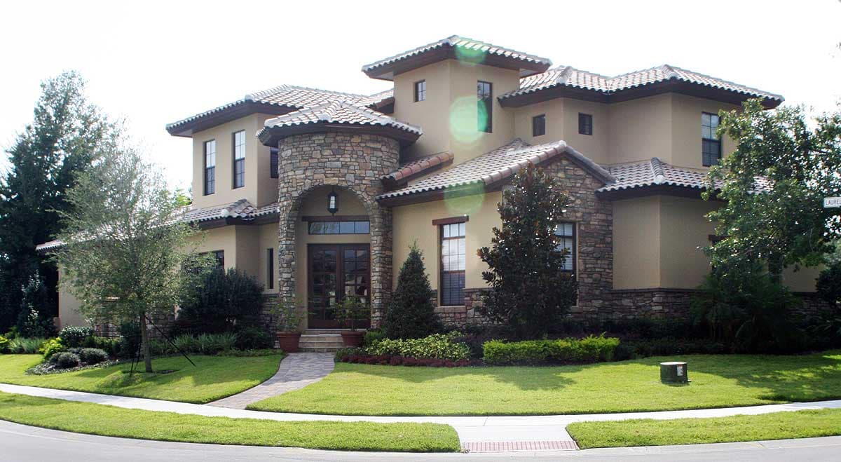 House plan exterior of a two-story home with a stucco finish, stone accents, arched entryway, and tiled roof.