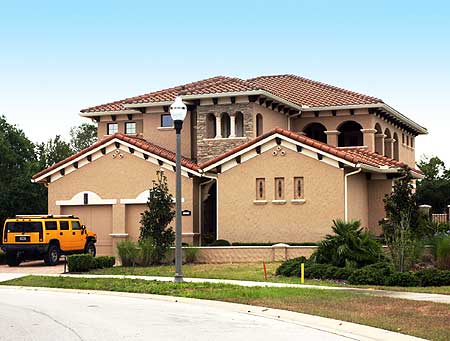 House plan exterior featuring a two-car garage, arched windows, tile roof, and Mediterranean architectural style.
