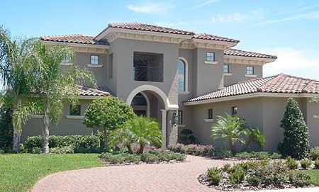 House plan exterior: Two-story Mediterranean style with arched entryway, tile roof, and multiple gables.