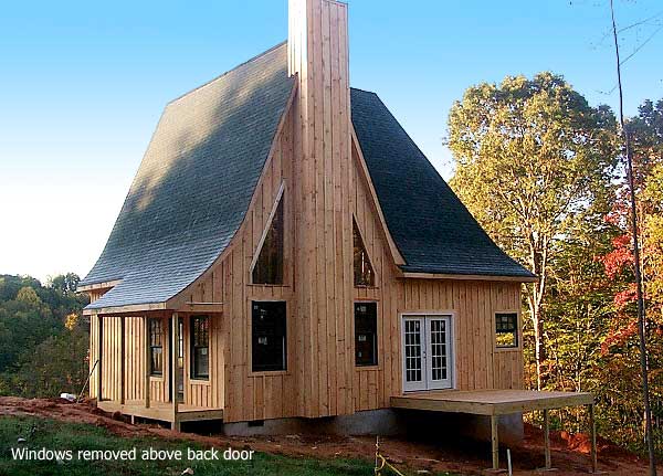 House plan exterior of a two-story timber-clad home with a curved roofline, prominent chimney, side porch, and deck.