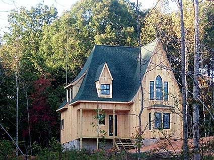 House plan exterior featuring a gambrel roof, dormer window, and Gothic-arched window detail.