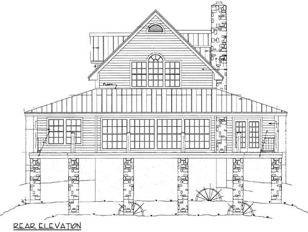 Rear elevation drawing of house plan showing stone foundation piers, large windows, and a prominent stone chimney.