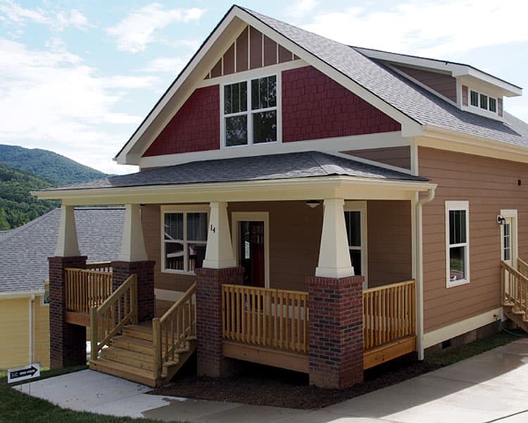 Craftsman style house plan exterior with covered front porch, gables, dormer window, and brick accents.