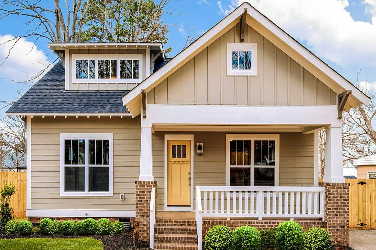Craftsman house plan exterior with a front porch, dormer, and gabled roofline. Features brick and siding exterior and multi-pane windows.
