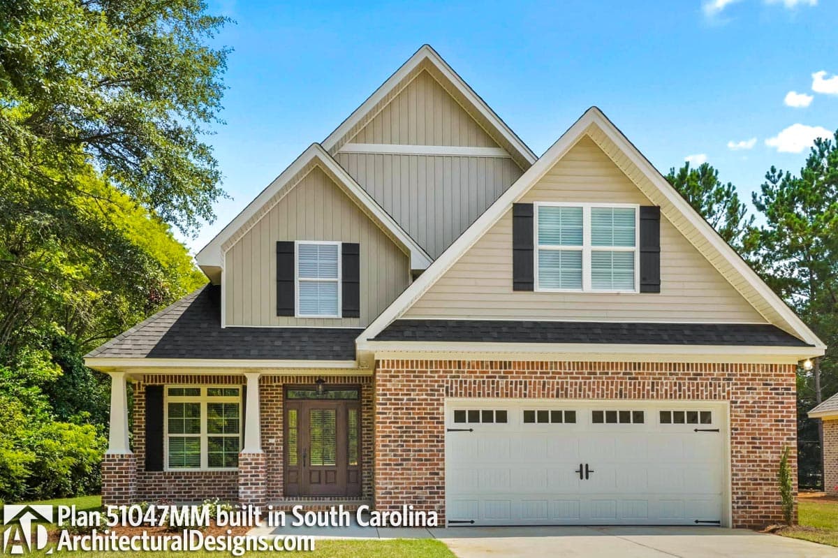 House plan exterior: Two-story, brick and vinyl siding, gabled roof, prominent front entry with columns, and attached two-car garage.