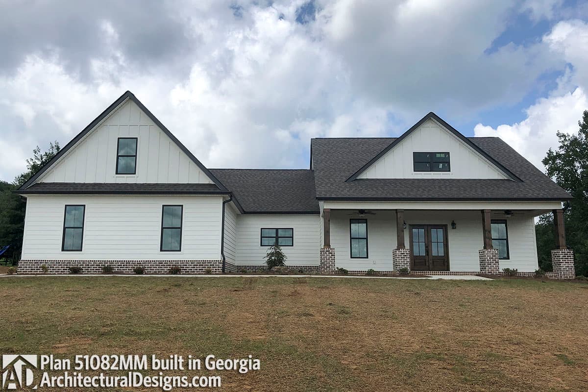 Modern Farmhouse exterior with gables, large front porch with wood columns, and white board-and-batten siding.