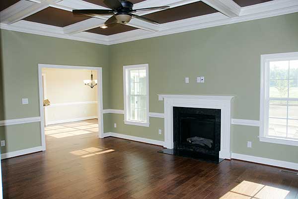 Living room with coffered ceiling, fireplace, and doorway to dining room.