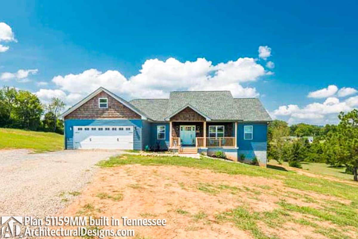House plan exterior: Ranch style, one story, blue siding, wood shingle gable, covered front porch, attached garage.