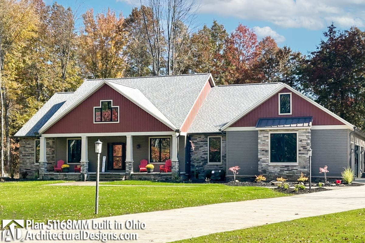 House plan exterior: Ranch-style, one story with covered front porch, stone accents, prominent gables, and side-entry garage.