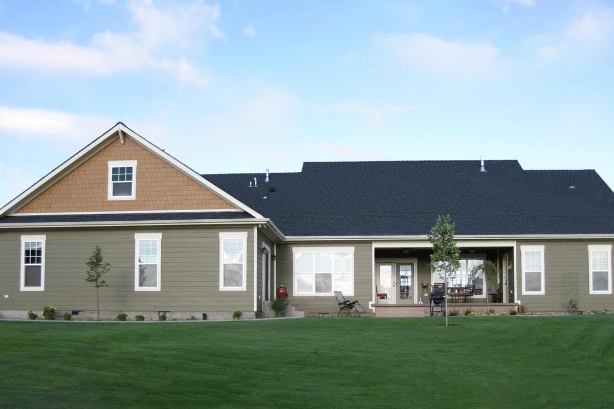House plan exterior of a single-story home with a gabled front, cedar shakes, and a covered porch.