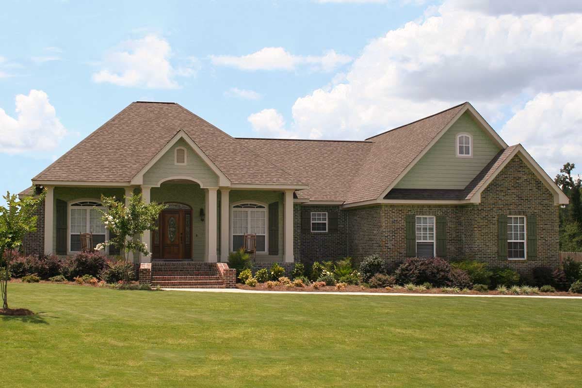 House plan exterior: One-story home with gabled roof, arched windows, brick facade, and covered entry porch with columns.