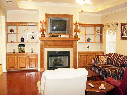 Interior rendering of a living room with a fireplace, built-in wood shelving units, and striped sofa.
