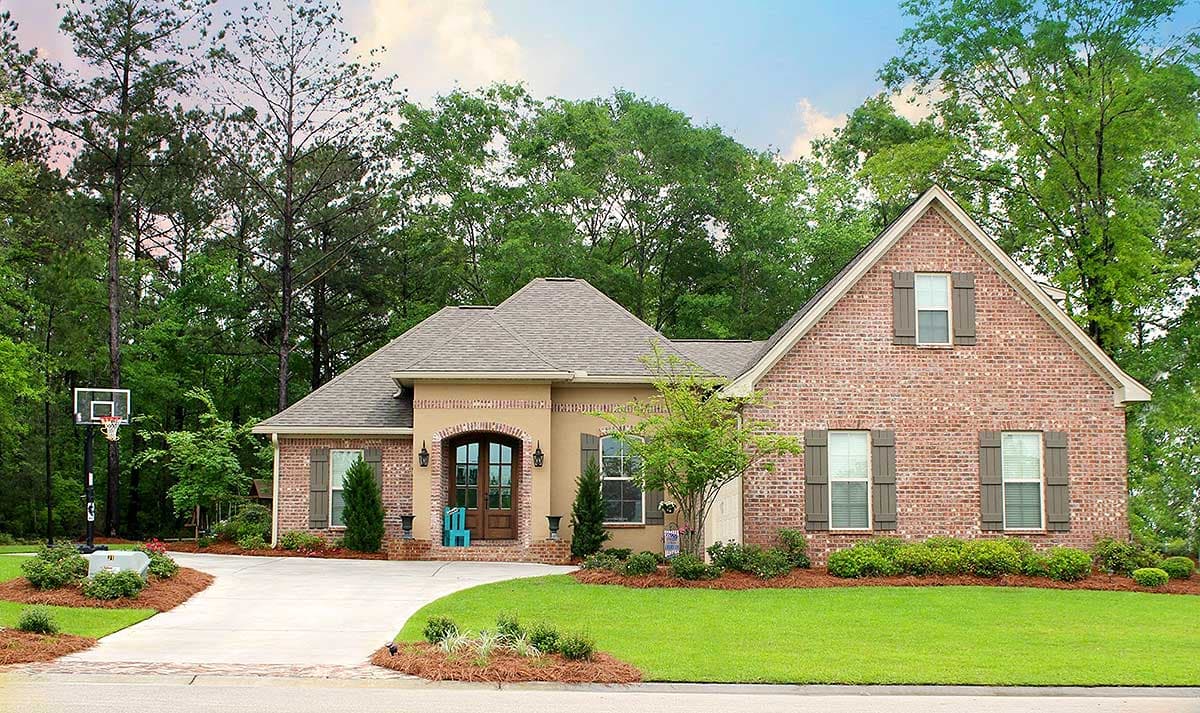 House plan exterior: brick and stucco, arched entry, gabled roof, dormer window, two stories.