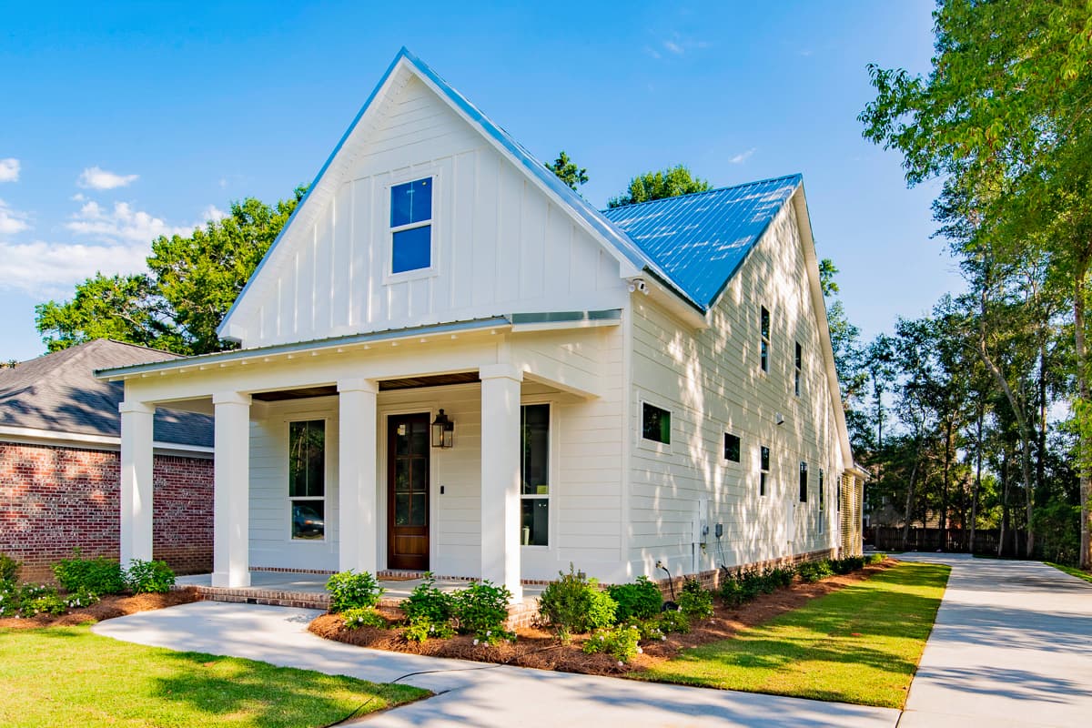 House plan exterior. Two-story Modern Farmhouse with a gabled roof, front porch with columns, and board-and-batten siding.