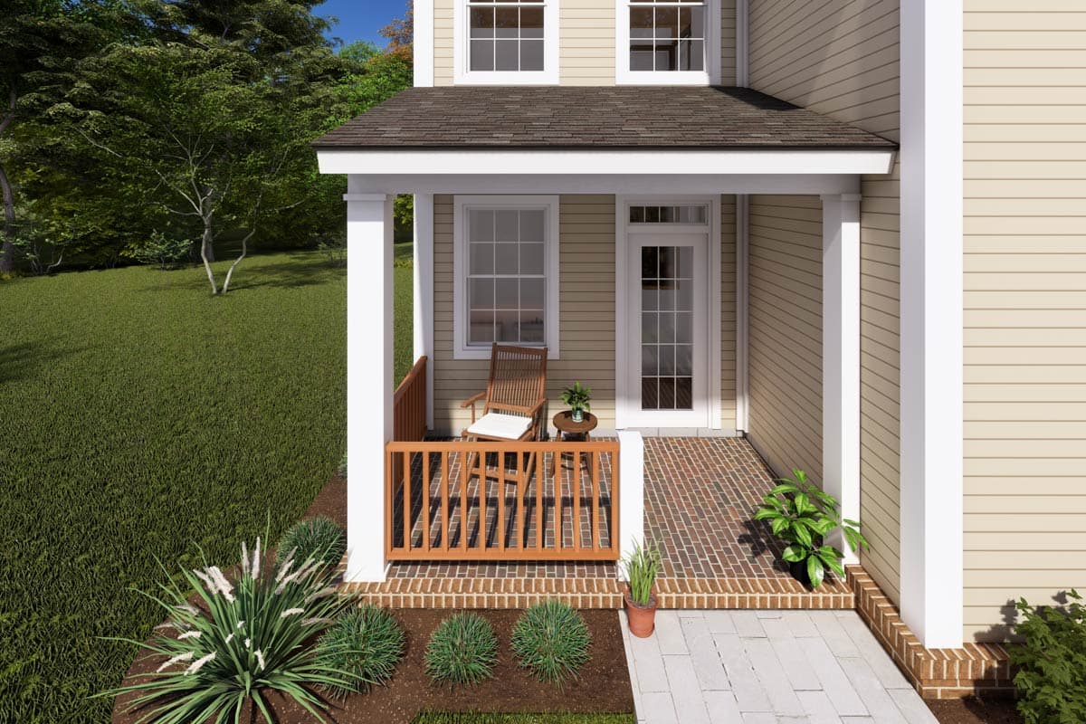 House plan exterior with a covered porch featuring wood railing, brick flooring, and two stories of tan siding.