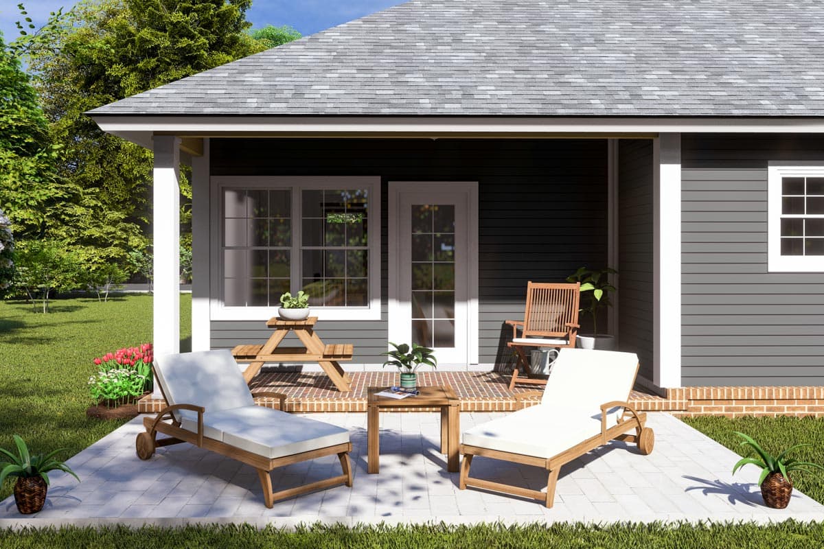 House plan exterior features a covered porch with two chaise lounges, a picnic table, and a chair.