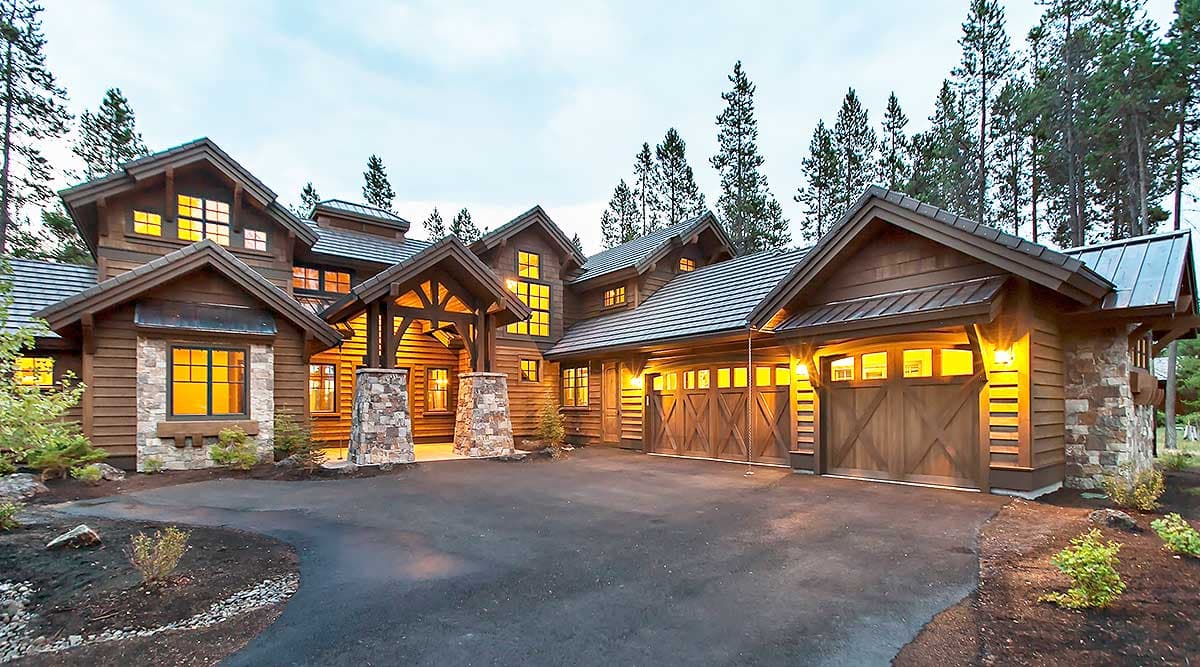 House plan exterior featuring a multi-story timber and stone lodge with a porte-cochère and attached three-car garage.
