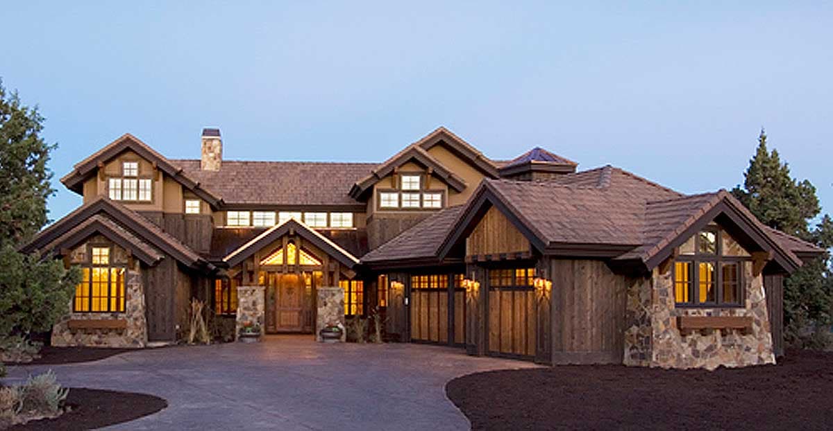 Mountain modern house plan exterior with stone and wood siding, multiple gables, and a large central entrance.