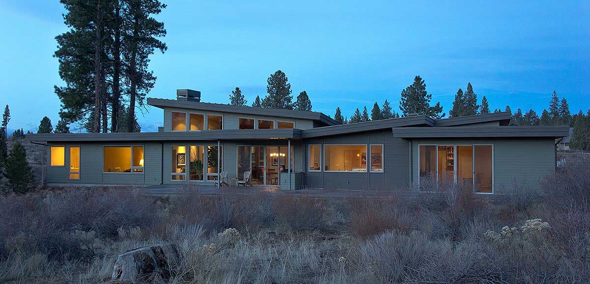 Modern house plan exterior with a low-pitched roof, large windows, and horizontal siding.