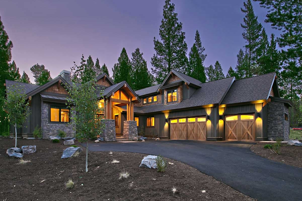 House plan exterior with stone and wood siding, covered entry, and a three-car garage with wooden doors.