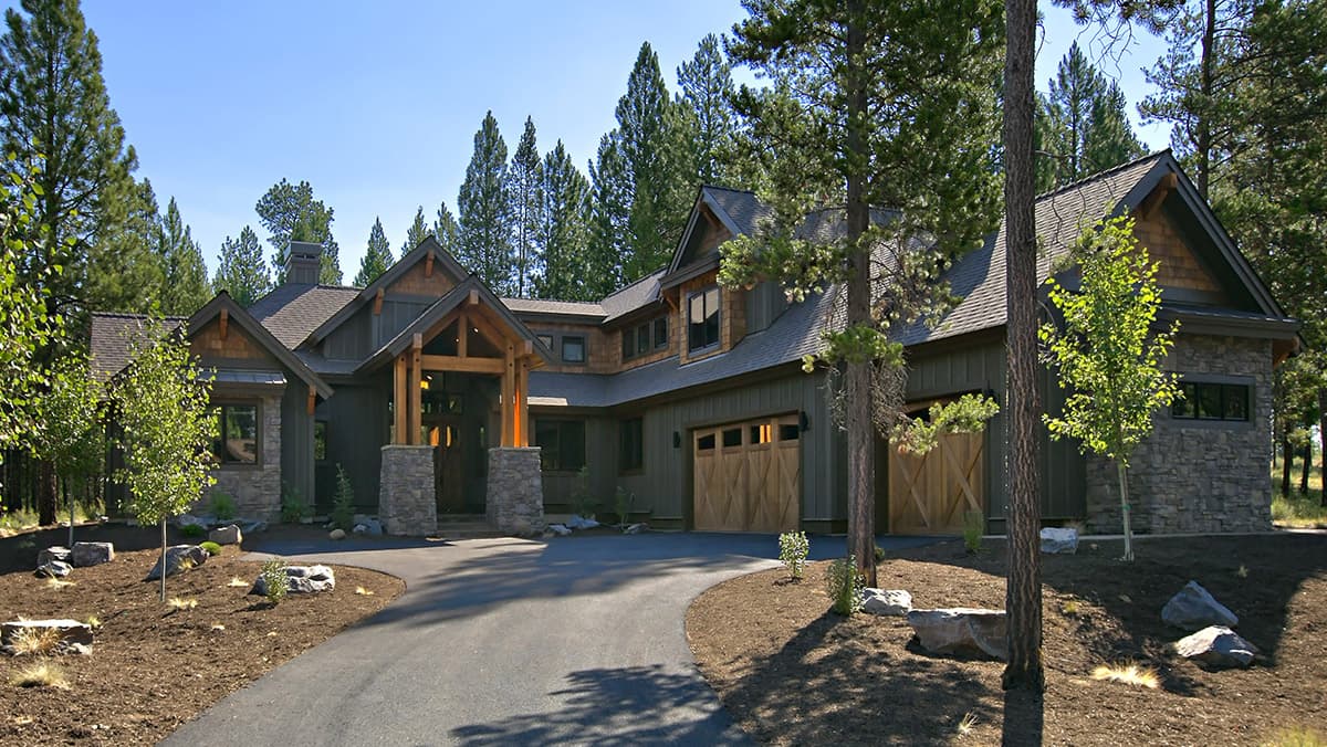 House plan exterior: Craftsman style, two stories, timber-framed entryway, stone accents, wood garage doors.