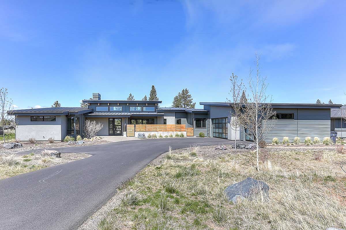 Modern house plan exterior with a single story, flat rooflines, glass garage door, and large horizontal windows.