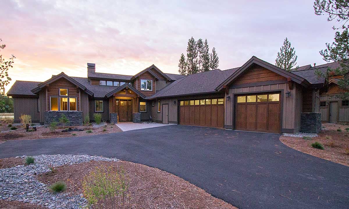 Modern Rustic house plan exterior with prominent gables, stone accents, and a three-car garage.
