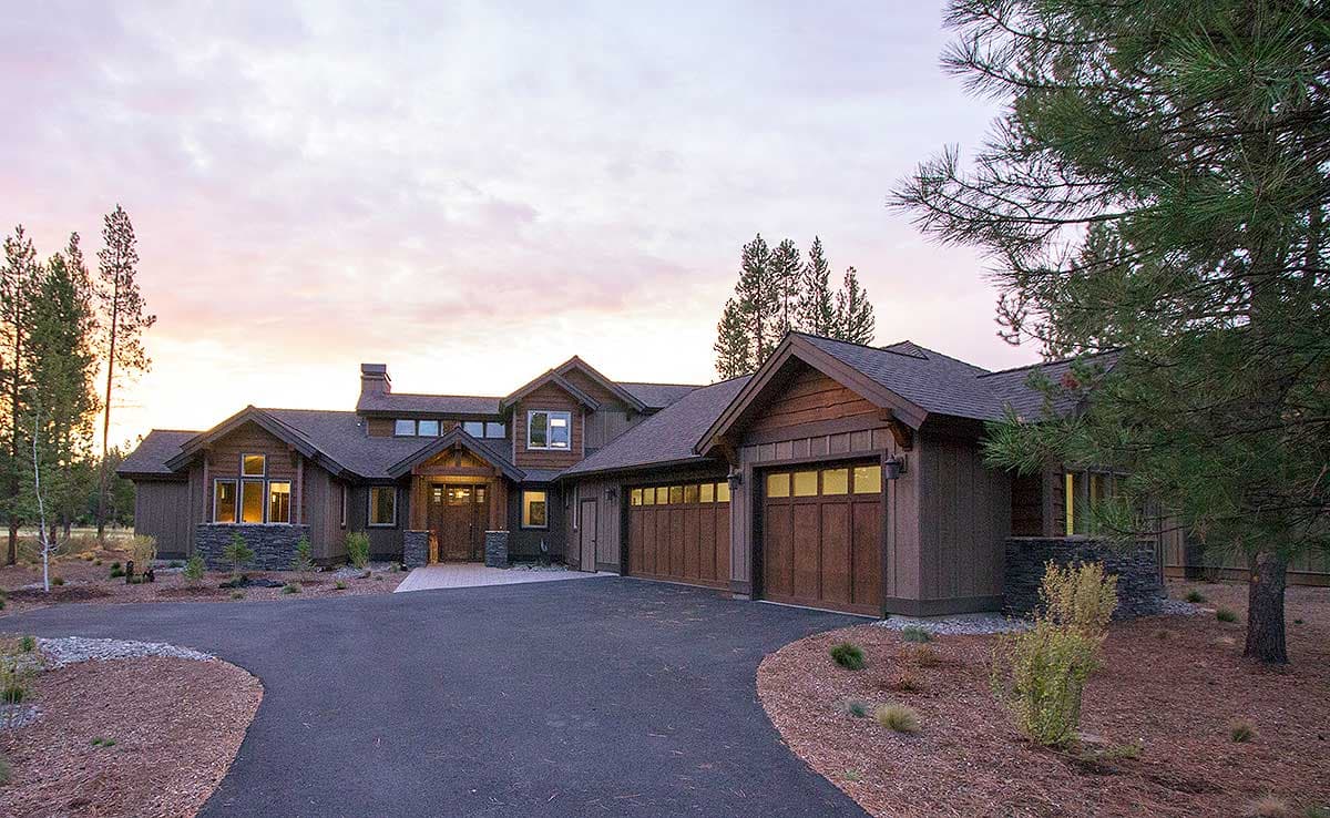 House plan exterior, two-story Modern Craftsman with stone accents, pitched roof, and three-car garage.