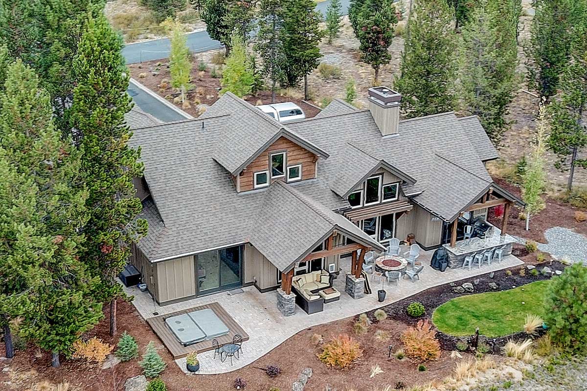 House plan exterior with multiple gables, dormers, covered patio with outdoor kitchen, and hot tub deck.