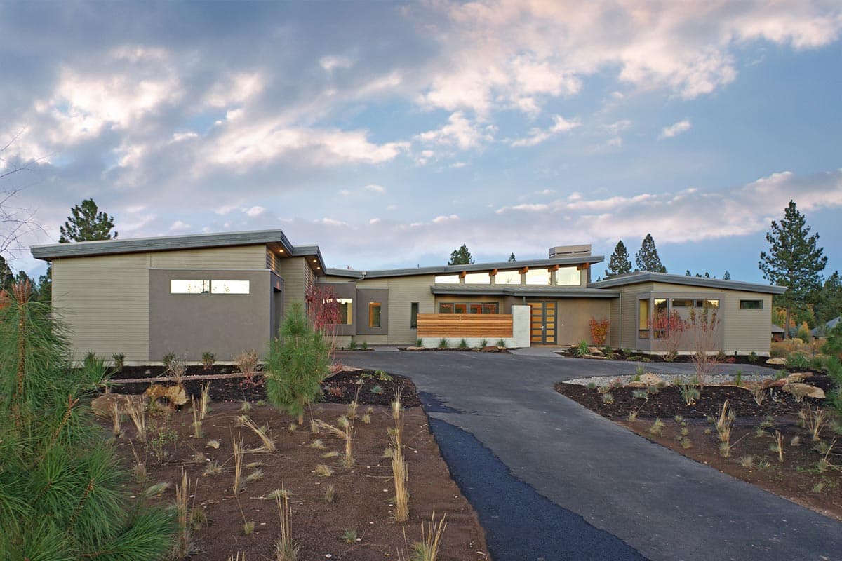 Modern single-story house plan exterior with a low-pitched roof, horizontal siding, clerestory windows, and a wood-slat screen.