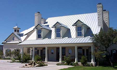 House plan exterior: Two-story Modern Farmhouse with wraparound porch, metal roof, dormers, and stone chimney.
