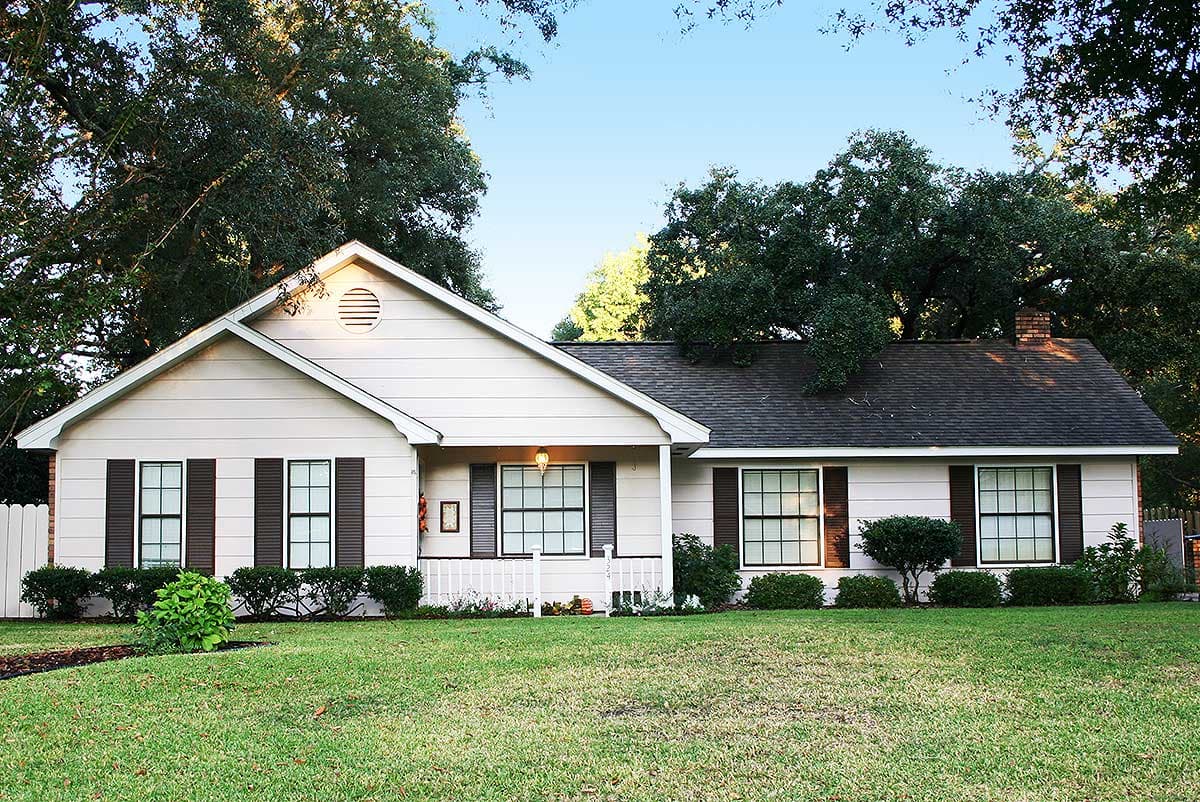 House plan exterior: Ranch style, one story, with gabled roof, central porch, and dark shutters on windows.
