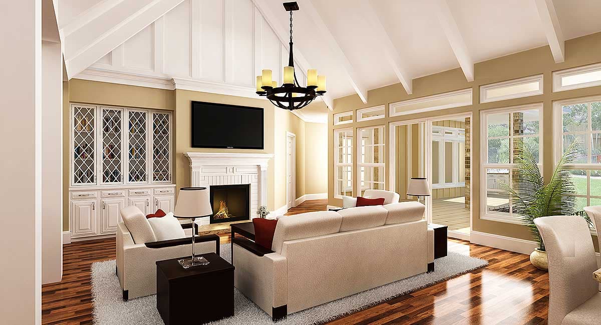 Interior view of a living room with vaulted beamed ceiling, fireplace, built-in cabinetry, and large windows.