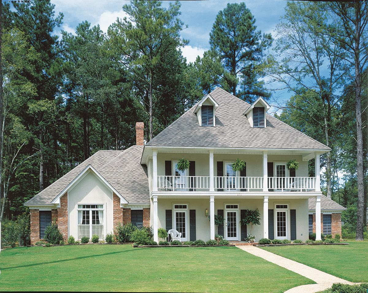 Two-story house plan exterior with a covered front porch, dormers, and brick accents.