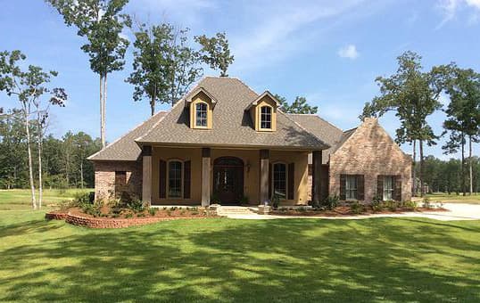 House plan exterior with stone accents, covered entry, dormers, and multipane windows.