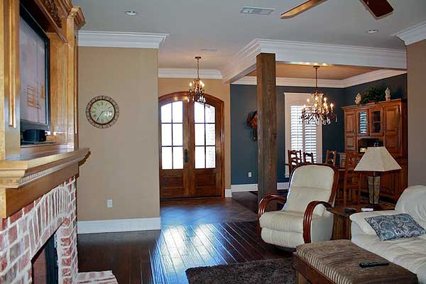 Interior view showing a living area with fireplace, double doors, and dining room with chandelier.
